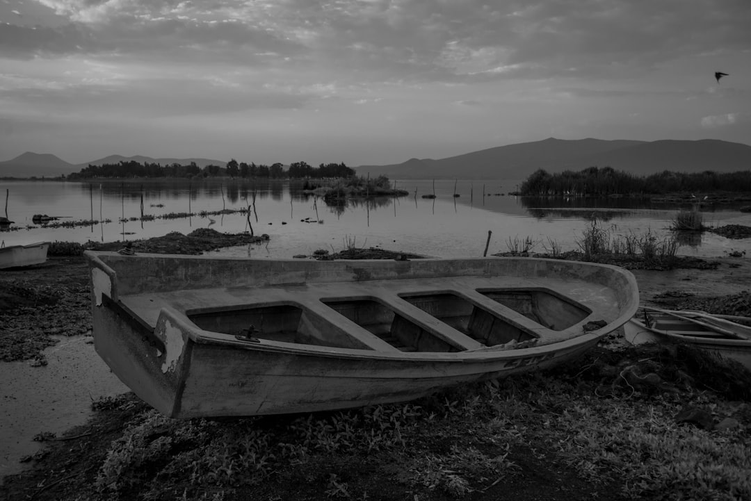 grayscale photo of boat on lake