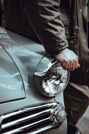 Model wearing a torque pulse muscle car jacket standing beside a classic Dodge Charger.