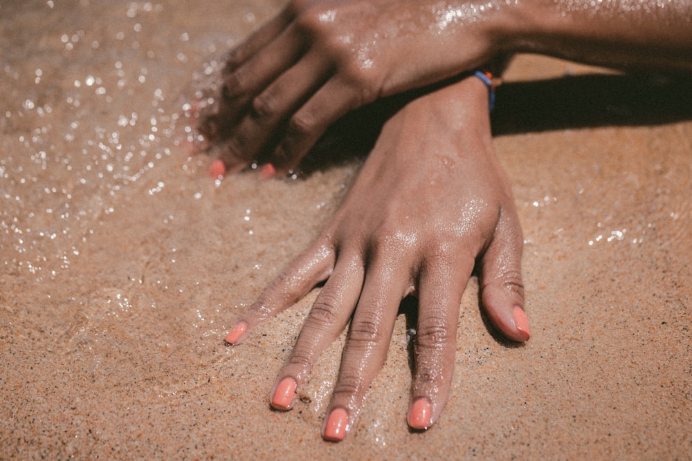 mano de la persona que muestra el esmalte de uñas