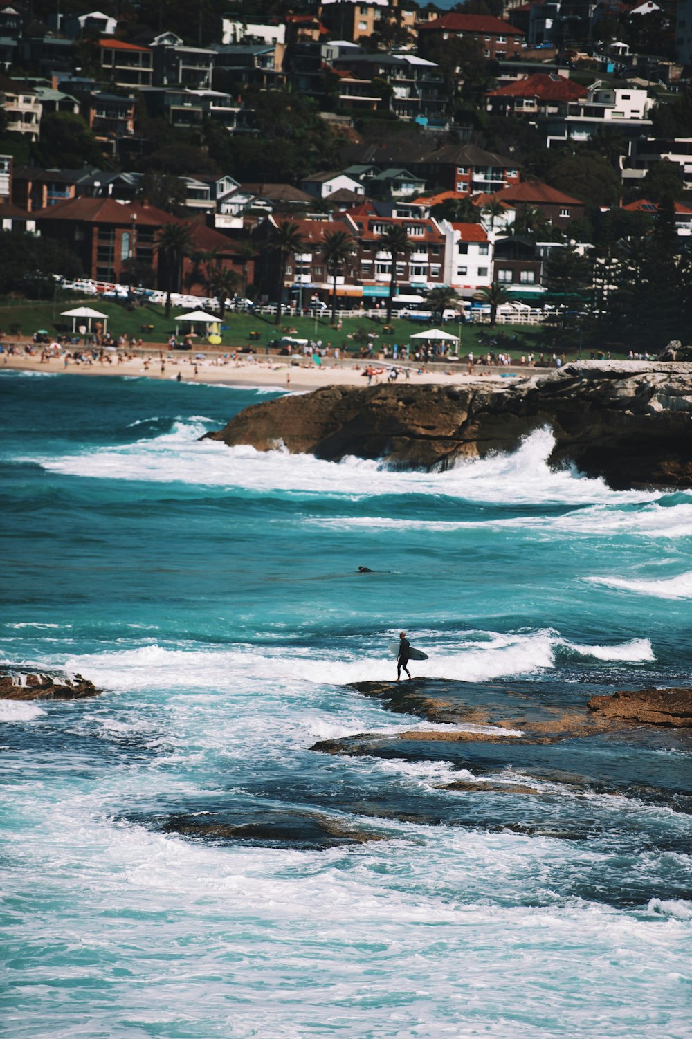 person carrying surfboard standing on shore