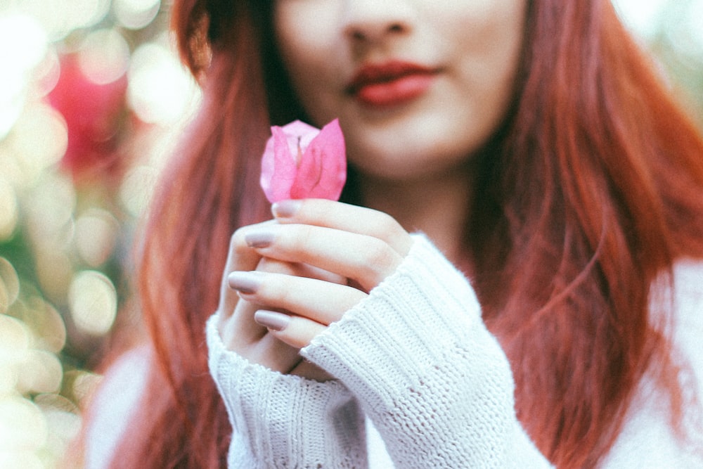 Femme tenant une rose rose