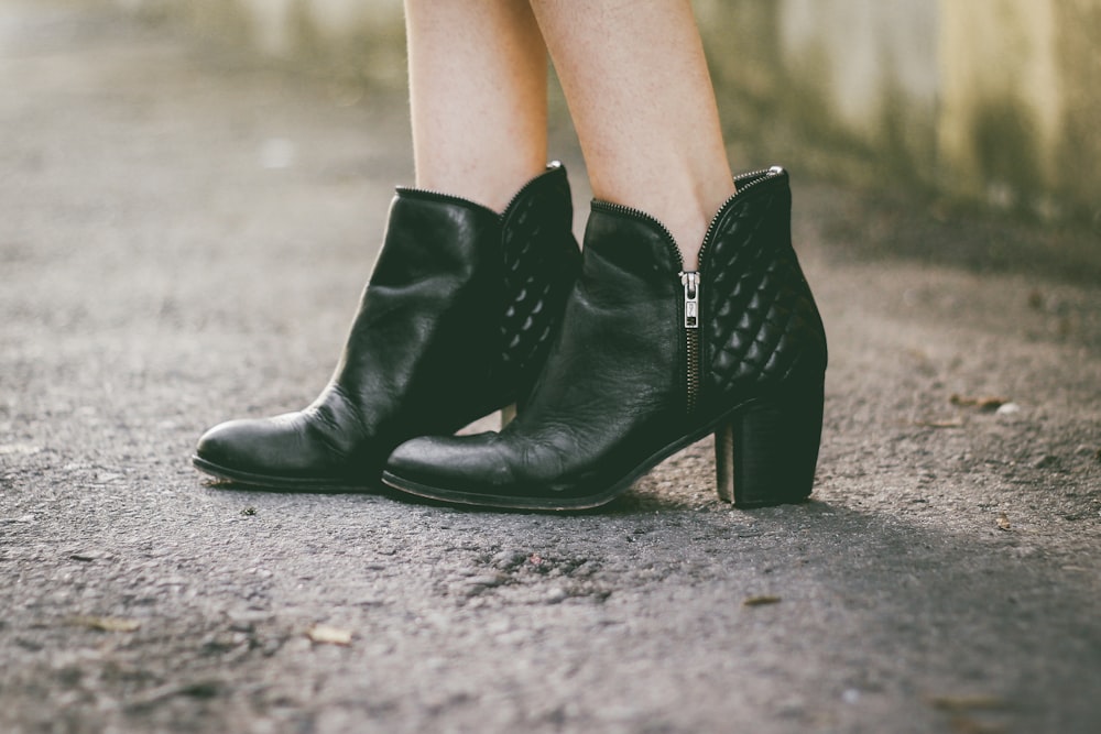donna in stivali neri con tacchi grossi in piedi sul pavimento grigio