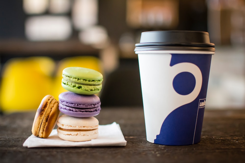 macaroons on tissue beside coffee cup