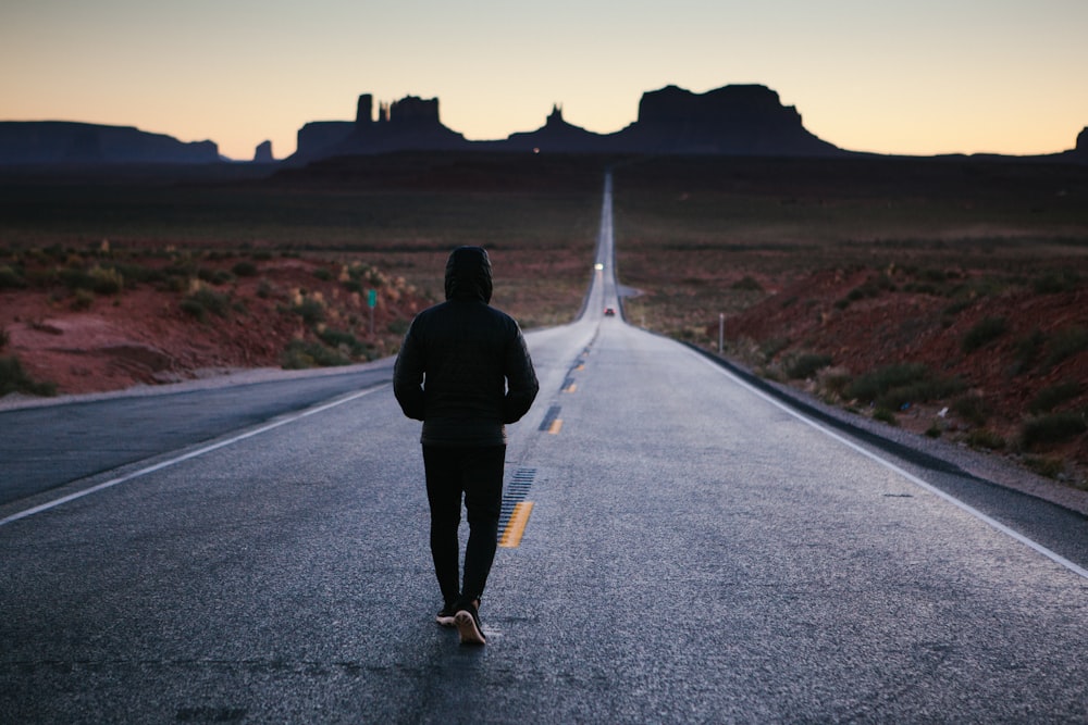 person walking in the center of the road