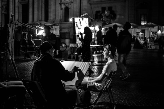 grayscale photography of people at the street near buildings during night