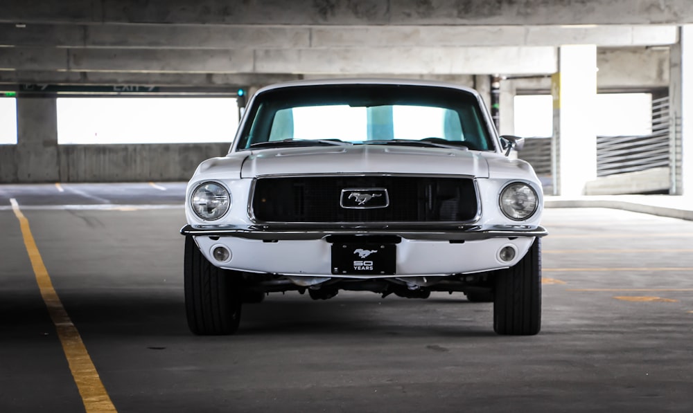 white Ford Mustang car on gray road