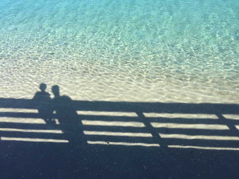 Silhouette of boy and man by fence