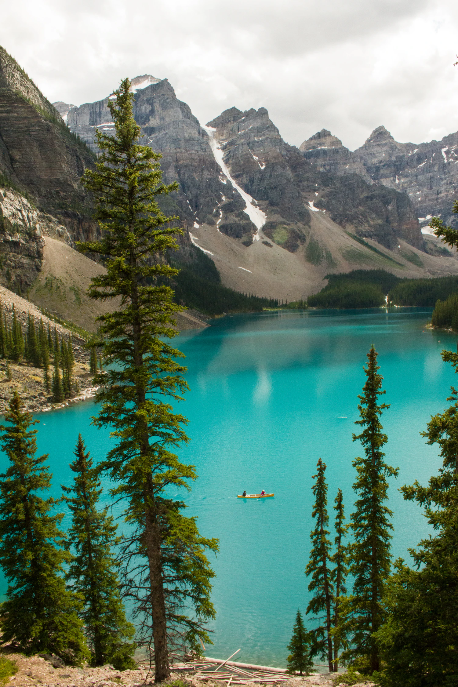 Canot solitaire sur un lac turquoise entouré de montagnes