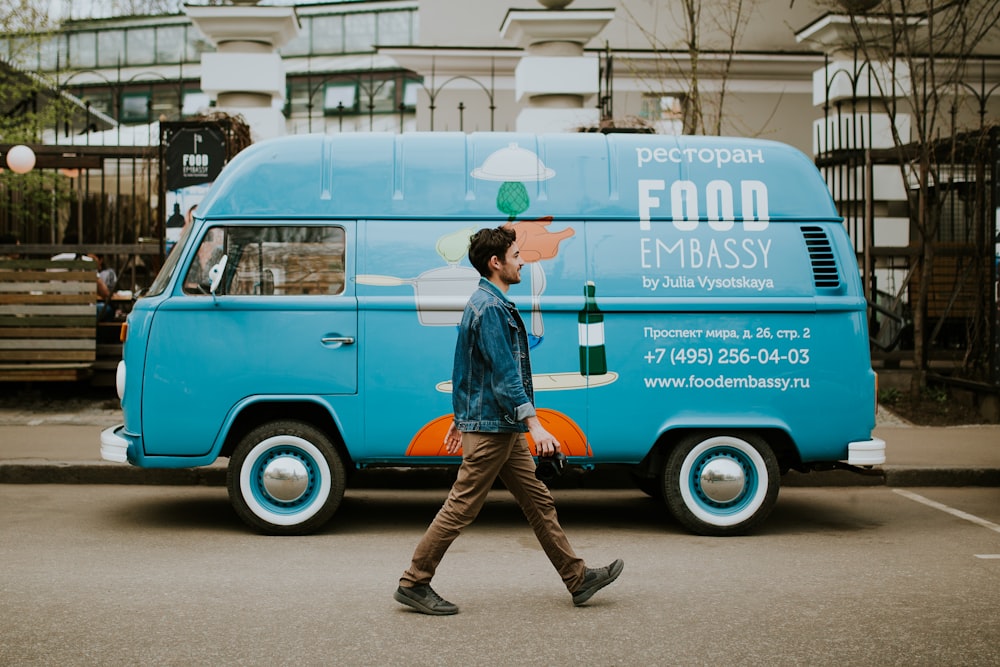 man walking beside van near concrete house