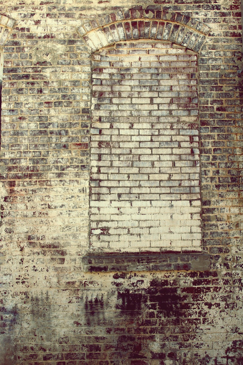 A brick building with bricks covering the opening where a window once was.