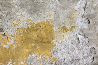 a yellow and gray wall with peeling paint