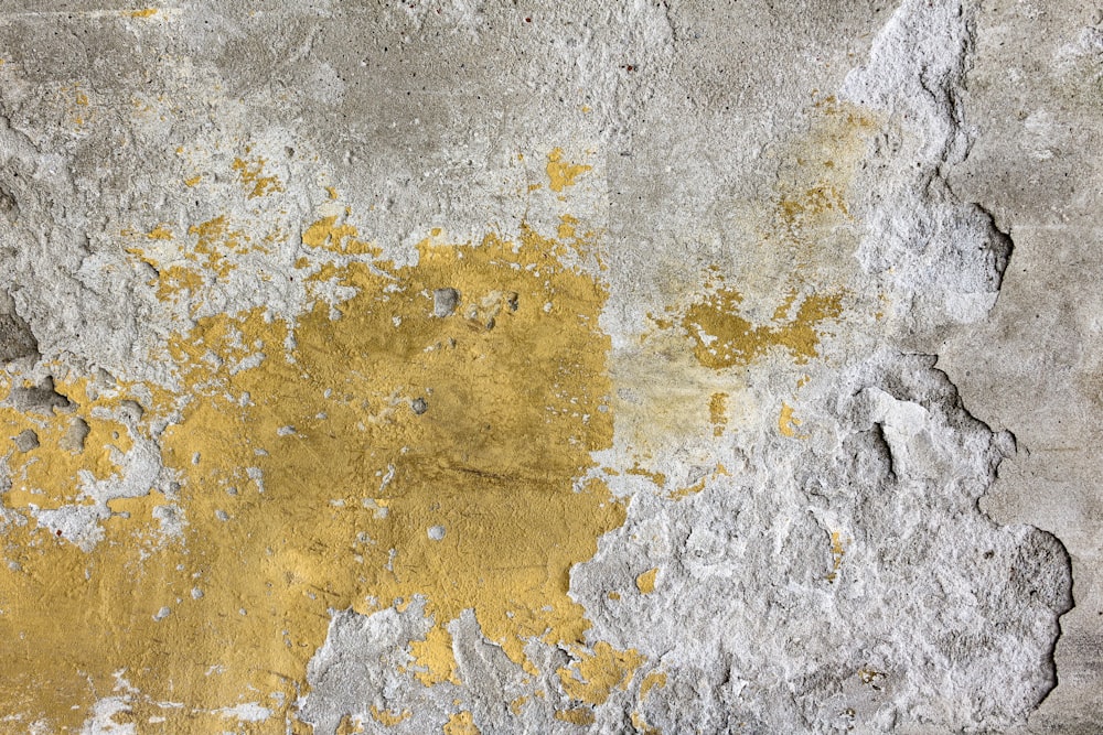 eine gelbe und graue Wand mit abblätternder Farbe