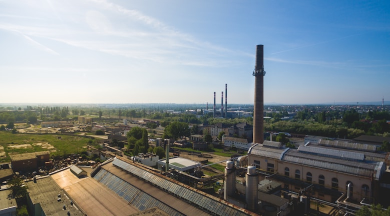 A panoramic view of the Trombay production unit with chimneys and industrial structures under a clear sky.