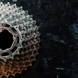 Close-up of a sleek bicycle gear against a bright yellow background