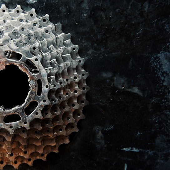 Close-up of a sleek bicycle gear against a bright yellow background