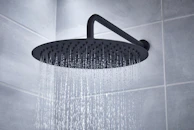 Shower filter attached to a modern showerhead with water flowing gently.