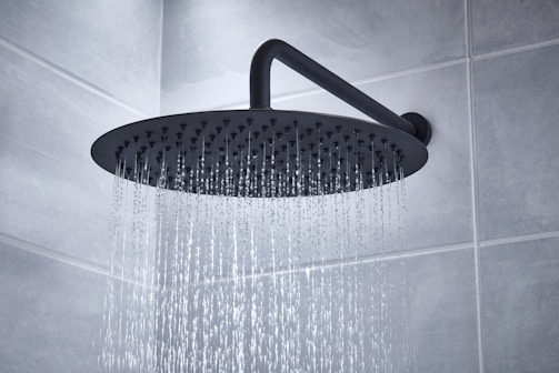 A high-tech shower head releasing a gentle cascade of water with LED temperature indicators.