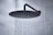 Newly installed rainfall shower head with water flowing gently.