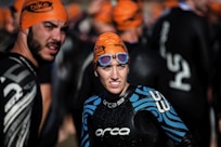 selective focus photography of woman wearing orange head cap and blue rashguard