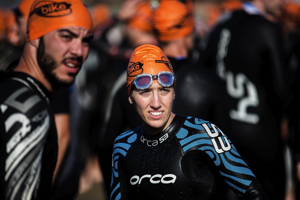 Photographie de mise au point sélective d’une femme portant un bonnet orange et un rashguard bleu