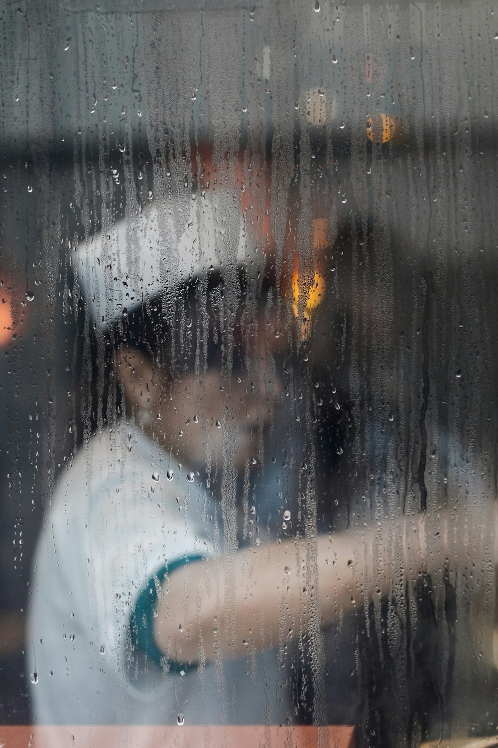 A cook at work seen through a rainy window