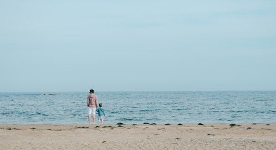 man and toddler standing on shore in Manchester-by-the-Sea United States