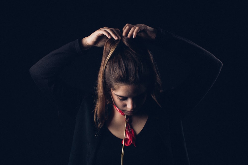 femme attachant les cheveux avec les deux mains