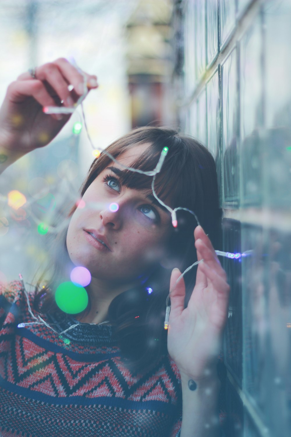 woman holding string lights