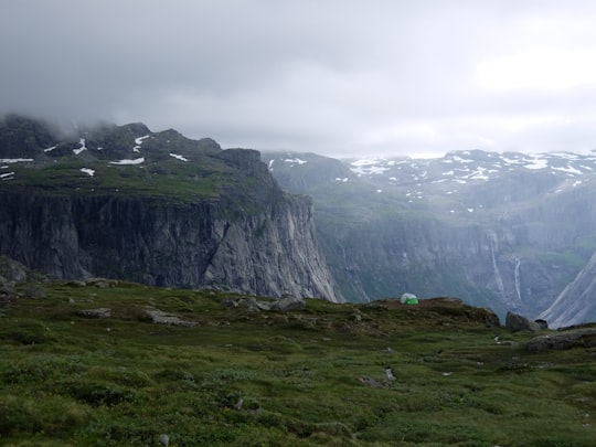 mountain range with grass and snow in Trolltunga Norway