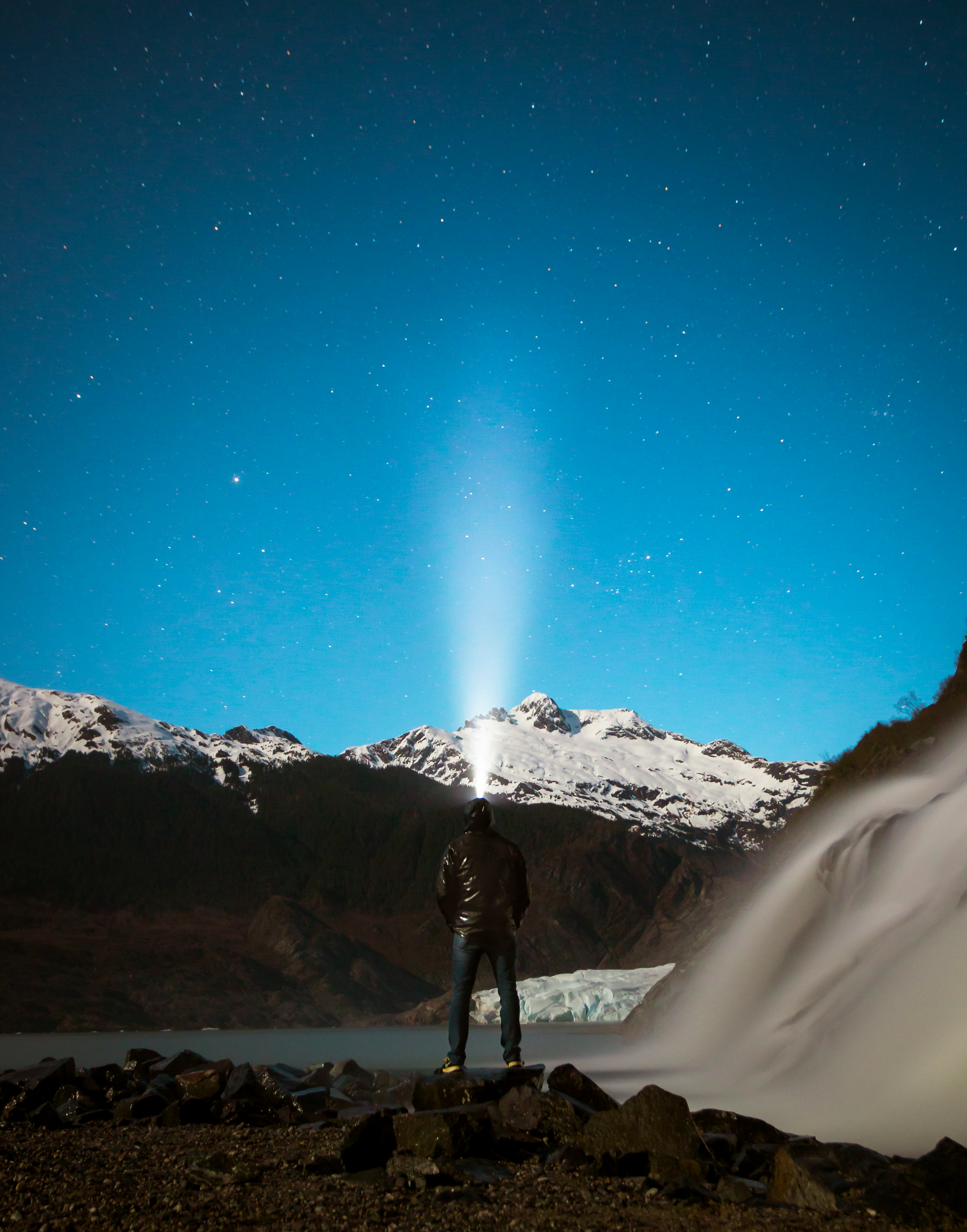 man facing snow capped mountain under clear sky