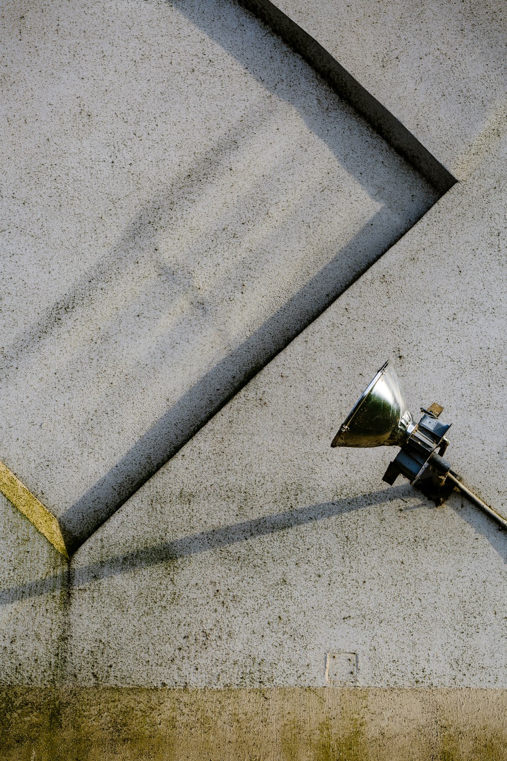 Lampe en acier inoxydable gris sur chaussée en béton gris