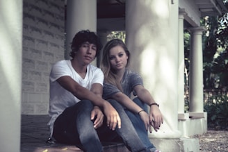 A couple relaxing on the porch of a peaceful farmhouse.
