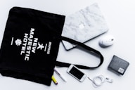 flat lay photography of tote bag beside iPhone and wallet