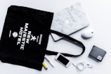flat lay photography of tote bag beside iPhone and wallet