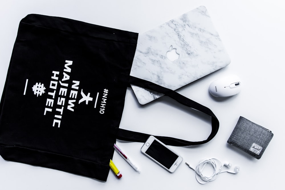 flat lay photography of tote bag beside iPhone and wallet