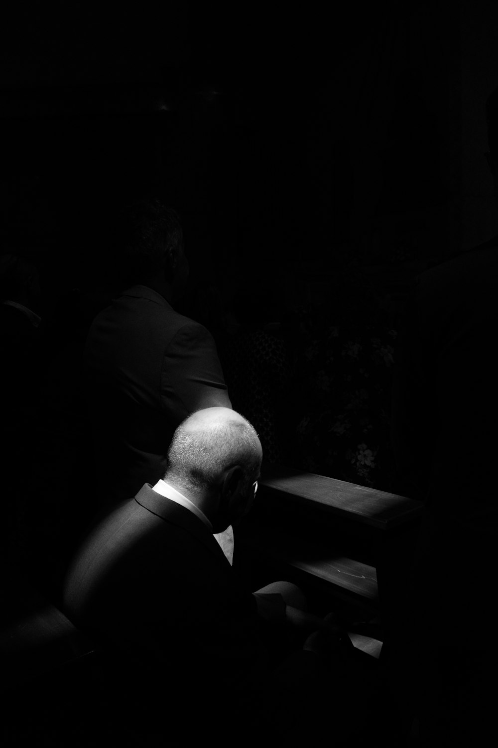 grayscale photo of man sitting on chair