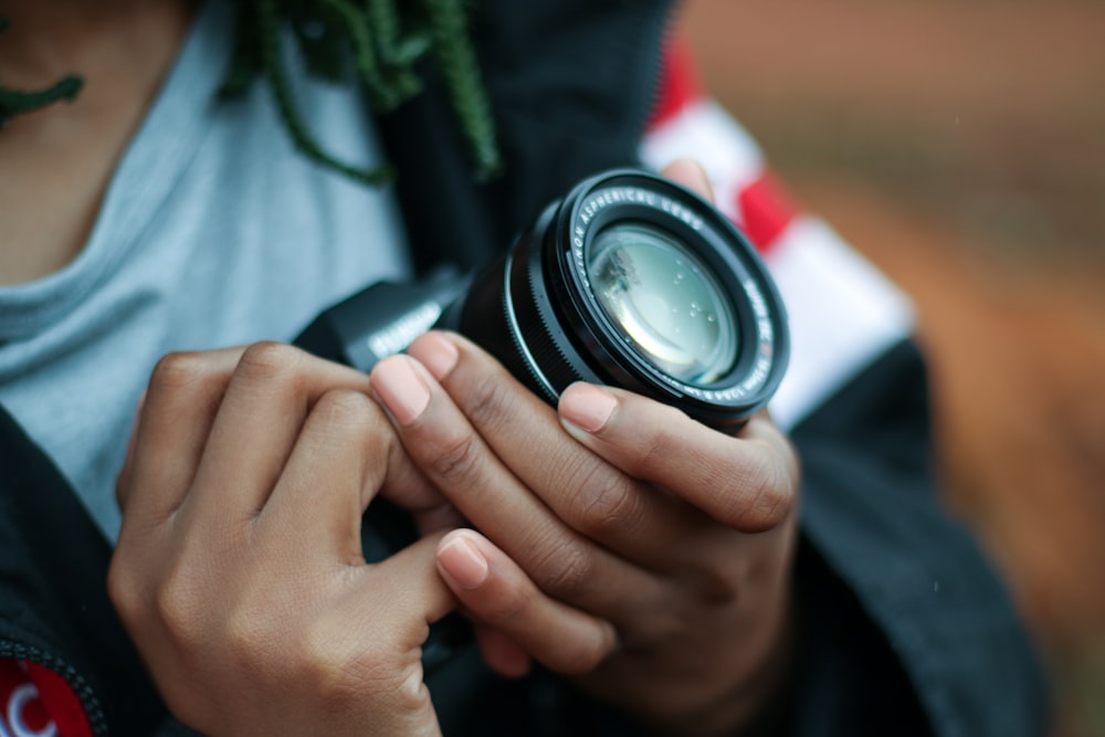 person holding black DSLR camera