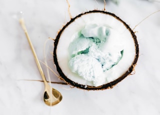 ice cream in coconut beside spoon