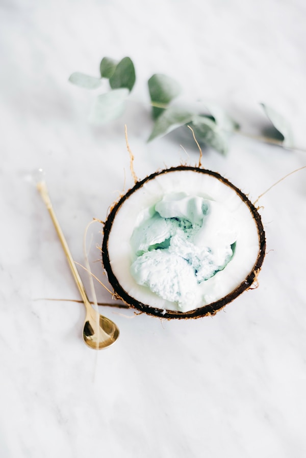 Ice cream in coconut beside spoon