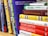 A collection of business and motivational books on a shelf, featuring titles like 'Greening Your Business,' 'Billions of Entrepreneurs,' 'Great Again,' and 'Higher Ambition.' The books are arranged vertically, showing a variety of colors and sizes.