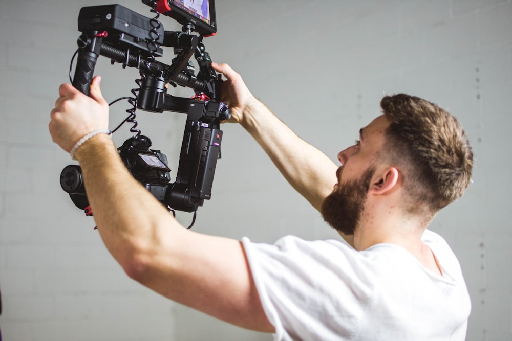 uomo che tiene la macchina fotografica con stabilizzatore