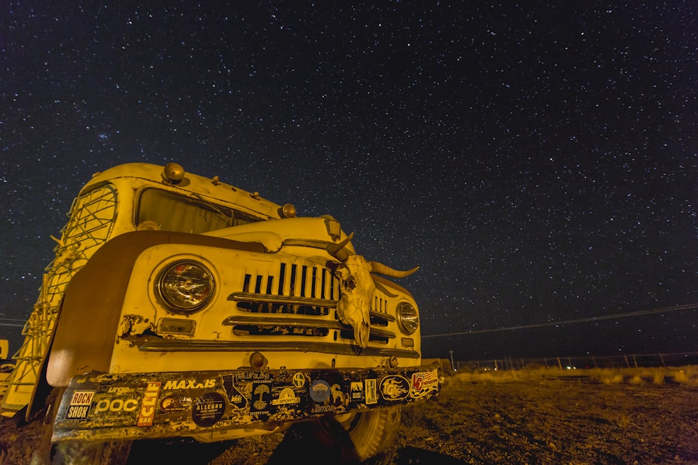 photo of white and brown bus with stars during nighttime