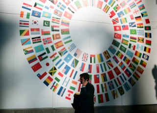 woman in black coat standing near round white red and blue wall