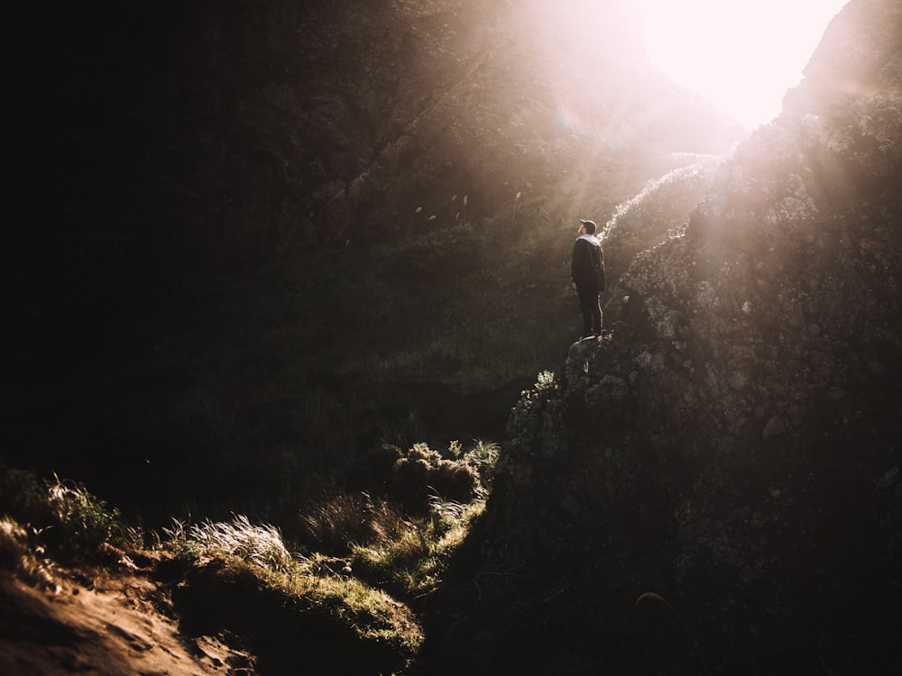 Hombre de pie en la montaña de roca durante el día
