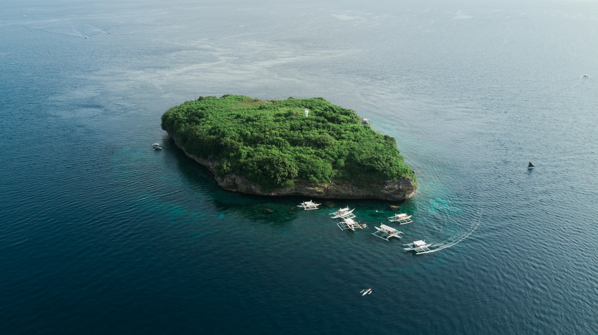Plunging view of coral reefs and turquoise island waters
