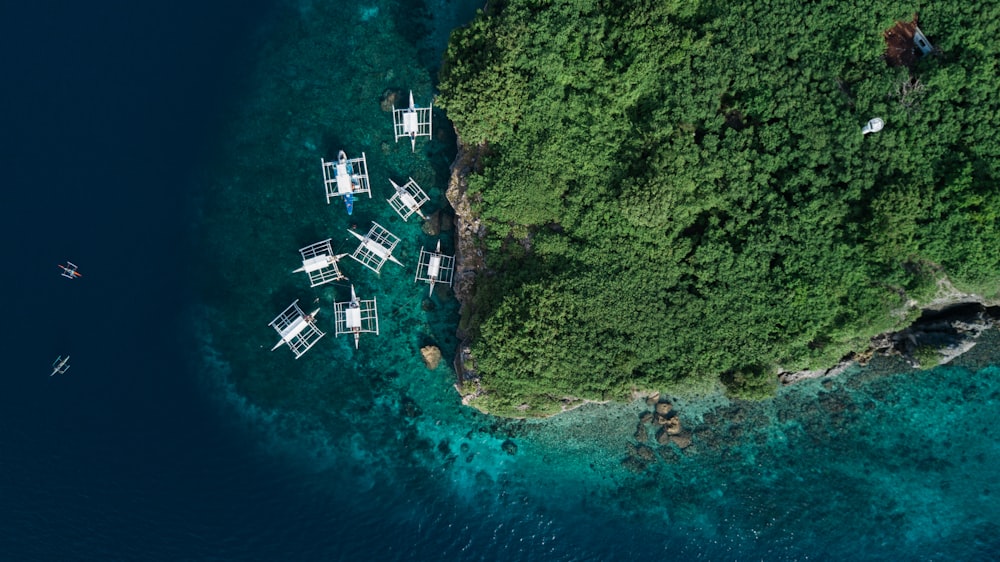 섬 근처의 여러 흰색 보트의 항공 사진