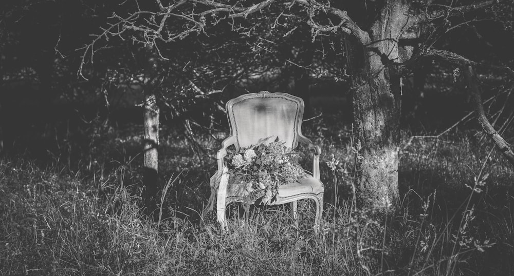 a chair sitting in a field next to a tree