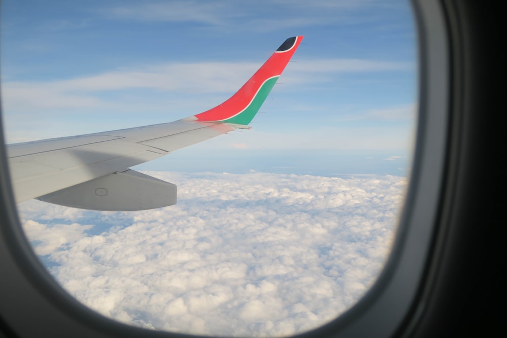 창문에서 본 흰색, 분홍색, 초록색 비행기 창문