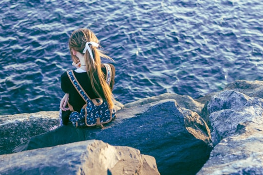 girl sitting on gray rocks in Perth WA Australia