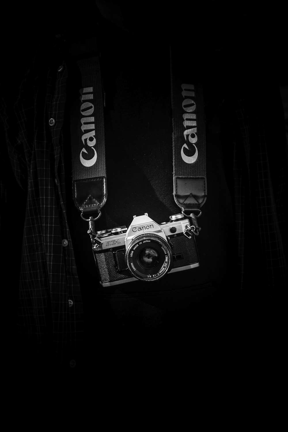 Cuerpo de cámara Canon gris y negro con cordón